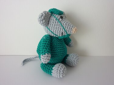 Gehäkelte Amigurumi‑Maus in Grau und Grün, seitliche Ansicht