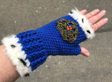 Königsblaue gehäkelte Handstulpe mit weißem Flauschbesatz und goldener Kronenverzierung
