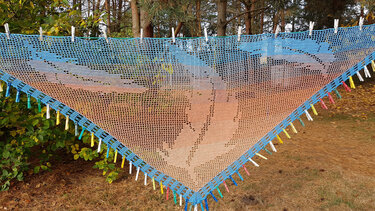 Gehäkeltes Dreieckstuch in Blau, Türkis und Orange mit Blattmuster an Wäscheleine
