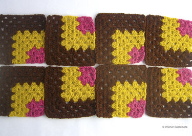 Gehäkelte Granny-Squares in Braun, Senfgelb und Rosa nebeneinander