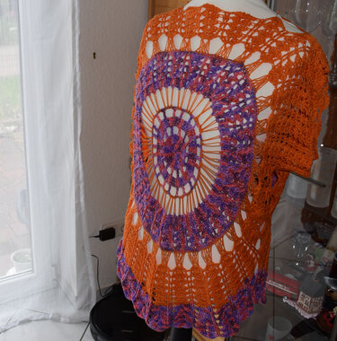 Häkelponcho Rückenansicht mit rundem orange-lila Motiv