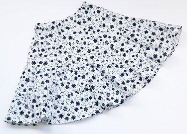 Detailansicht: ausgestellter weißer Kinderrock mit gerafftem Bund und dunkelblauem Blumenmuster