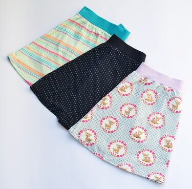 Drei Kinder
Röcke mit Streifen-, Punkte- und Rehkitzmuster auf weißem Hintergrund.