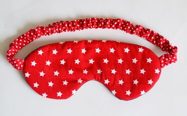 Genähte rote Schlafmaske mit weißen Sternen und gepunktetem elastischem Band