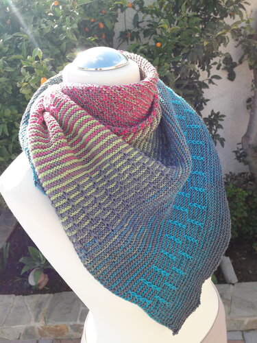 Triangle knitted shawl in teal, gray, lime and rose draped on a mannequin, showing garter stitch and slipped-stitch diamond motif