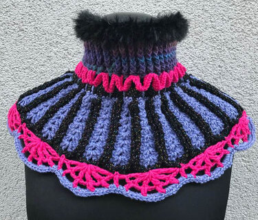 Gehäkelter Kragenschal in Schwarz, Lila und Pink mit flauschigem Kragen auf einer schwarzen Schaufensterpuppe
