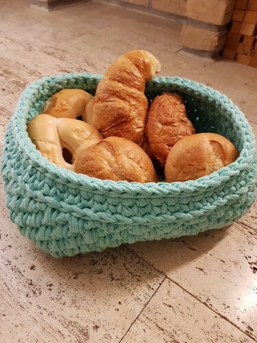 Schnell gehäkeltes türkises Körbchen mit Brötchen auf hellem Fliesenboden