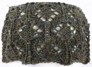 Gestricktes Spitzenprobestück in moosgrün mit Lochmuster und senkrechten Rippen