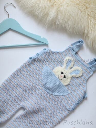 Gehäkelter Baby-Strampler blau-beige gestreift mit Hasentasche und hellblauem Kleiderbügel