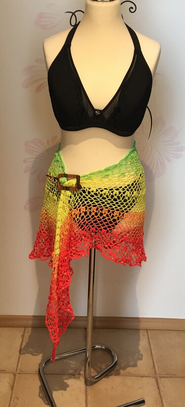 Schwarzer Bikini mit gehäkeltem Netz-Pareo in grün-gelb-orange-rot und Holzschließe