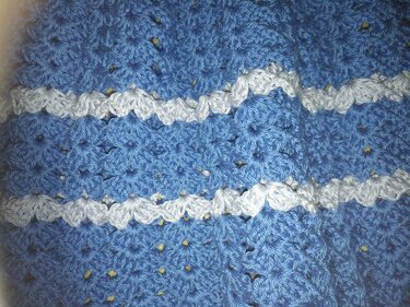 Nahaufnahme gehäkeltes blau-weißes Muschelmuster, Babydecke oder -kleidungsstück