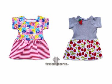 Zwei kurzärmelige Babykleider: buntes Katzenoberteil mit gestreiftem Rock; graues Oberteil mit Kirschrock und Erdbeer-Applikation.