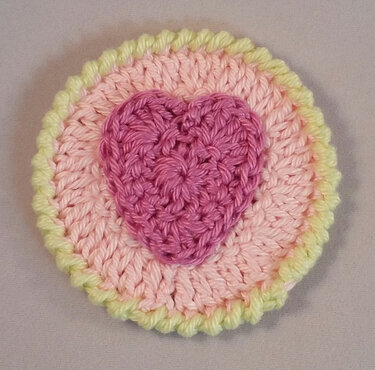 Kleine runde Häkel-Applikation mit rosafarbenem Herz