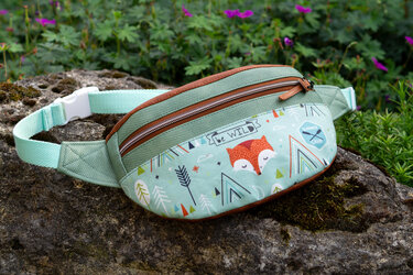 Mintgrüne Bauchtasche mit Fuchs- und Waldmotiv auf moosigem Stein