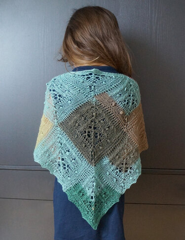 Rückansicht einer Person mit braunem Haar, die ein dreifarbiges, dreieckiges Lacetuch in Mint, Braun und Beige mit feinem Loch- und Noppenmuster trägt.