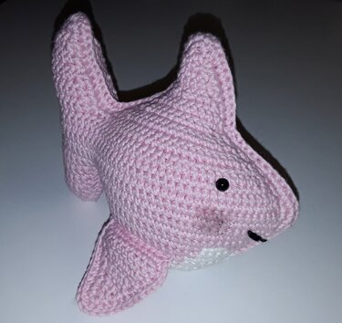 Rosa gehäkelter Amigurumi-Hai mit schwarzem Auge und weißem Bauch