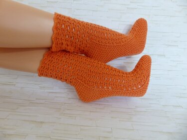 Orange gehäkelte mittellange Socken mit Ajourmuster an Beinen