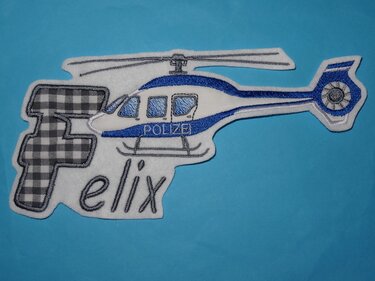 Bestickter Aufnäher: weiß-blauer Polizeihubschrauber mit kariertem Buchstaben F und dem Namen Felix auf blauem Hintergrund.