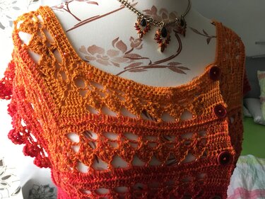 Gehäkeltes ärmelloses Top in Orange-Rot mit Lochmuster, Perlen und seitlicher Knopfleiste auf Schneiderpuppe
