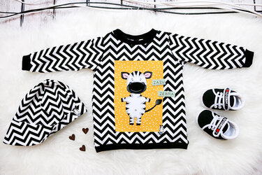 Kinder-Sweatshirt mit gelbem Panel und Zebra-Applikation, begleitet von Mütze und Babyschuhen
