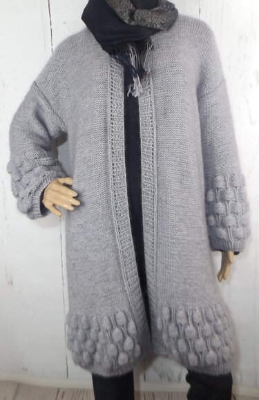 Grau gestrickte lange Damenjacke mit strukturierter Borte an Saum und Ärmeln an einer Schaufensterpuppe