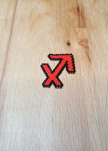 Bügelperlen Schütze-Symbol in Rot mit schwarzer Umrandung, auf Holz