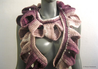 Gehäkelter Rüschenschal in Rosé- und Beigetönen an grauem Torso