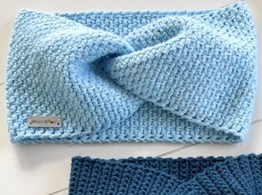 Hellblaues gehäkeltes Stirnband mit verdrehtem Knoten, darunter ein dunkelblaues Stirnband