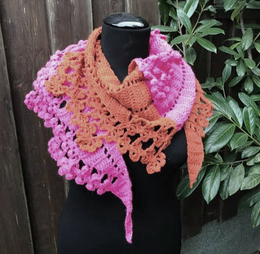 Asymmetrisches gehäkeltes Dreieckstuch mit Muschelkante in Rosa und Rost auf schwarzer Büste