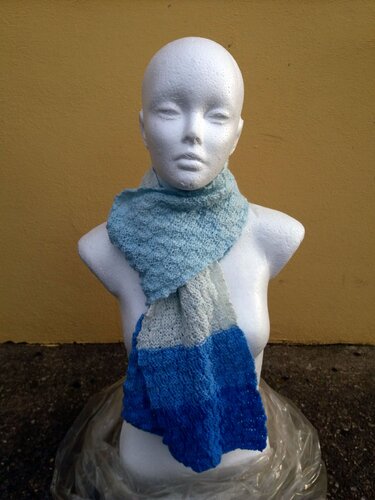 Schaufensterpuppe trägt Farbblock-Schal in Hellblau, Hellgrau und Dunkelblau vor gelber Wand