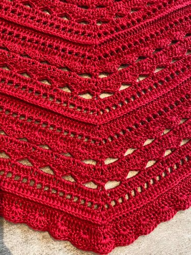 Detailaufnahme rotes Dreieckstuch mit V-Zunahmen, Ajourreihen und Muschelrand