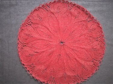 Rotes rundes Deckchen mit filigranem Blatt- und Spitzenmuster