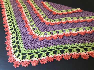 Lila gehäkeltes Dreieckstuch mit grüner Rankenborte und lachsrosafarbenen Blüten