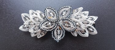 Aufwendig gearbeiteter Haarschmuck aus Perlen und facettierten Glasperlen auf dunklem Grund