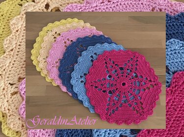 Mehrere runde gehäkelte Untersetzer in Pastell- und kräftigen Farben, fächerförmig auf Holzfläche