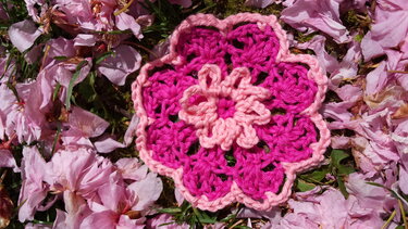Zweifarbige gehäkelte Blume in Pink auf rosa Blütenblättern