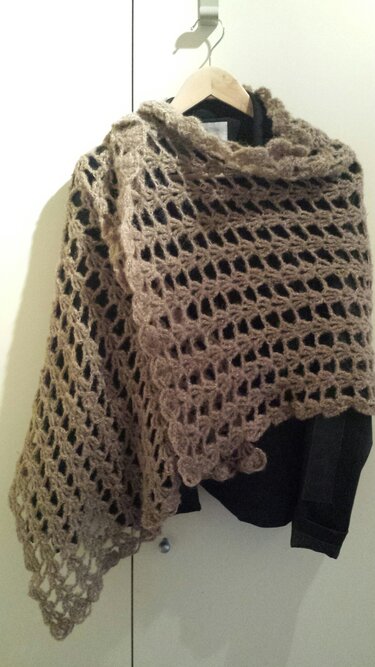 Taupefarbenes gehäkeltes Dreieckstuch mit offenem Muster an einem Bügel