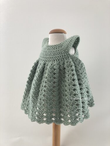 Mintgr
es geh
keltes Babykleid mit Muschelmuster und Wellensaum auf Puppe