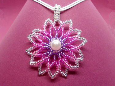 Blumenförmiger Perlen-Anhänger in Rosa und Silber mit zentraler runder Perle an hellem Band