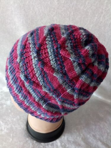 Gestrickte Damen-Strickmütze mit Streifen in Pink, Blau und Grau auf einem Kopfmodell