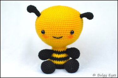 Gehäkelte gelb-schwarze Amigurumi-Biene mit lächelndem Gesicht