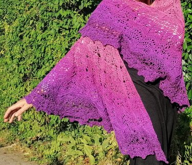 Halbrundes gehäkeltes Tuch mit Pink‑Lila Farbverlauf und Spitzenrand, über die Schulter gelegt