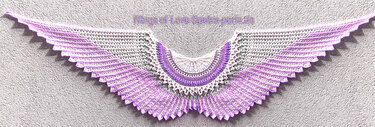Wing-shaped crochet shawl in white and purple with openwork stitches and scalloped edge.