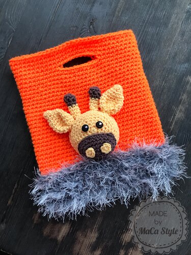 Orange quadratische Häkel­tasche mit Grifföffnung, grauem Fellrand und aufgesetzter Amigurumi-Giraffe