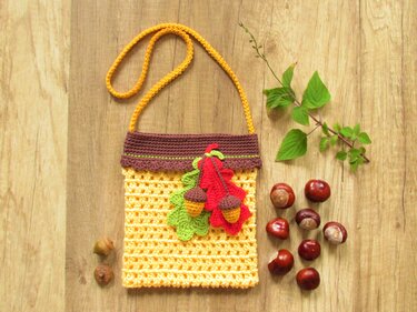 herbstliche gehäkelte Umhängetasche gelb mit roten und grünen Blatt-Applikationen und Eicheln