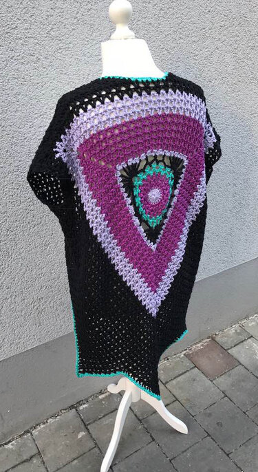 Schwarze gehäkelte Damenweste mit großem dreieckigem Mandala in Violett, Flieder und Türkis auf Schaufensterpuppe