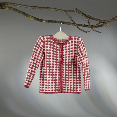 Rote und weiße gestrickte Kinderjacke mit Gittermuster an Holzbügel