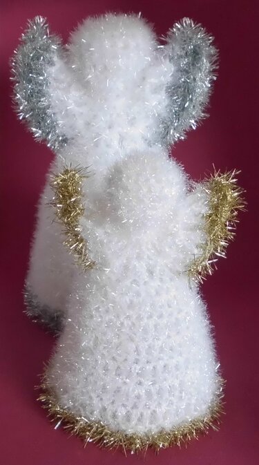 Rückansicht zweier flauschiger, weißer Häkelengel mit silbernen Flügeln und goldenen Glitzerdetails vor pinkem Hintergrund.