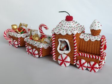 Hand-crocheted gingerbread-style train with icing trim, candy-cane wheels, two wagons filled with wrapped chocolates and a Santa figure in the cab