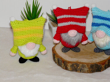 Drei Amigurumi-Wichtel mit gestreiften Mützen in Grün, Rot und Hellblau